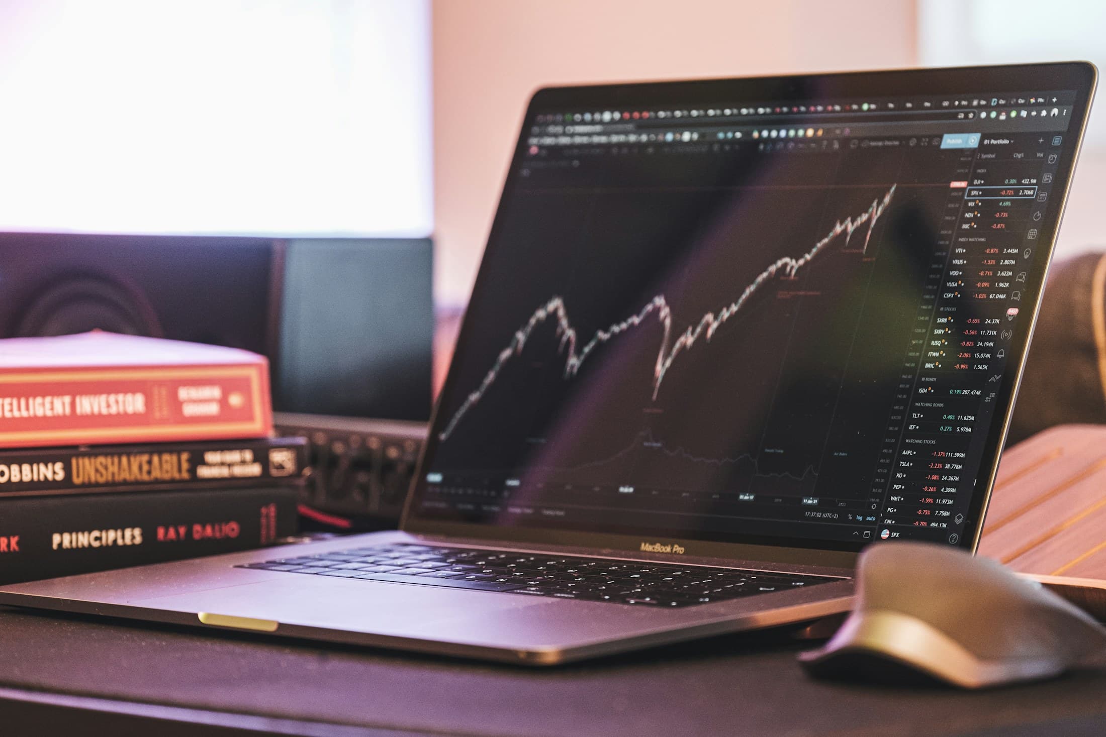 A thoughtful investing setup: an upward market chart beside the classics of investing.