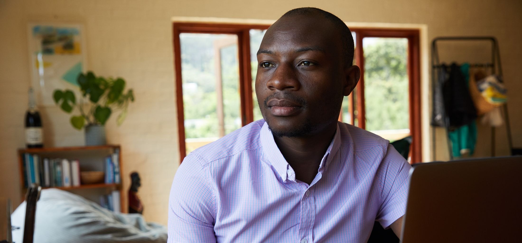 A young African investor reviewing the markets on a laptop at home.